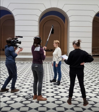 Im Foyer der Technischen Universität Berlin finden Dreharbeiten zum 75. Jahrestag der Neugründung statt. Zu sehen ist Julia Meyer-Brehm mit dem Filmteam.